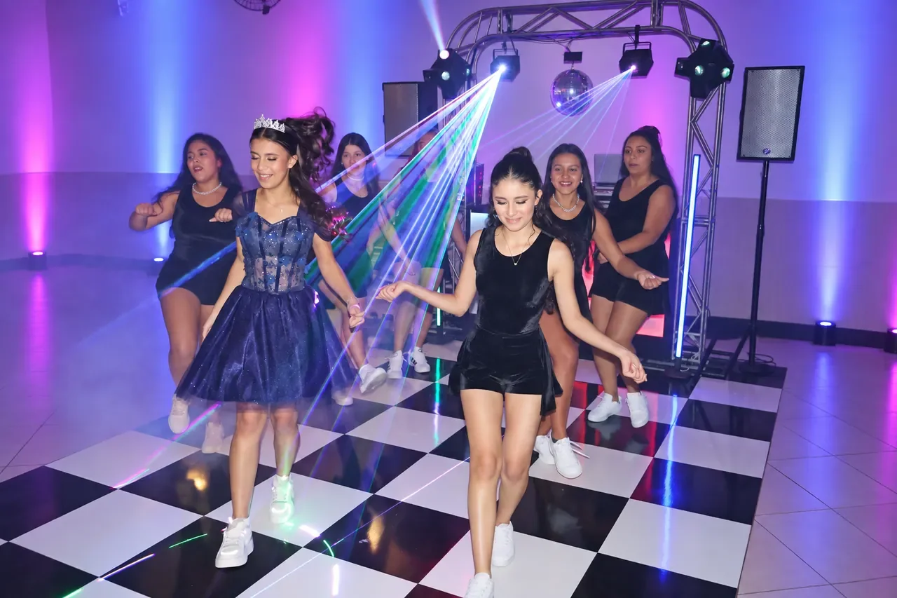Pista de dança dos 15 anos da Alice com coreografia e luzes coloridas.