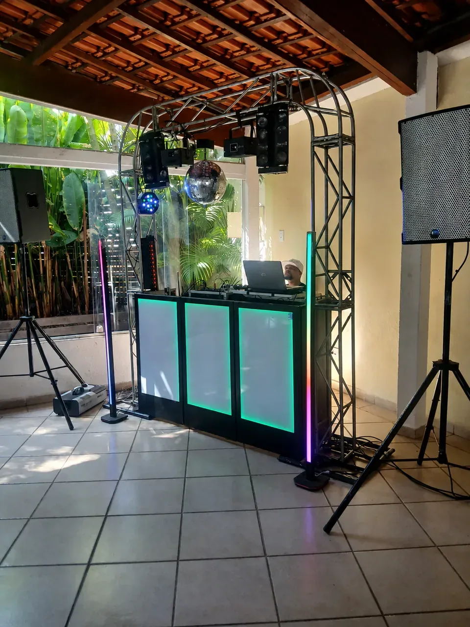 Montagem CSOM em varanda de eventos. Estrutura completa com globo espelhado, iluminação e caixas de som em ambiente integrado ao jardim.