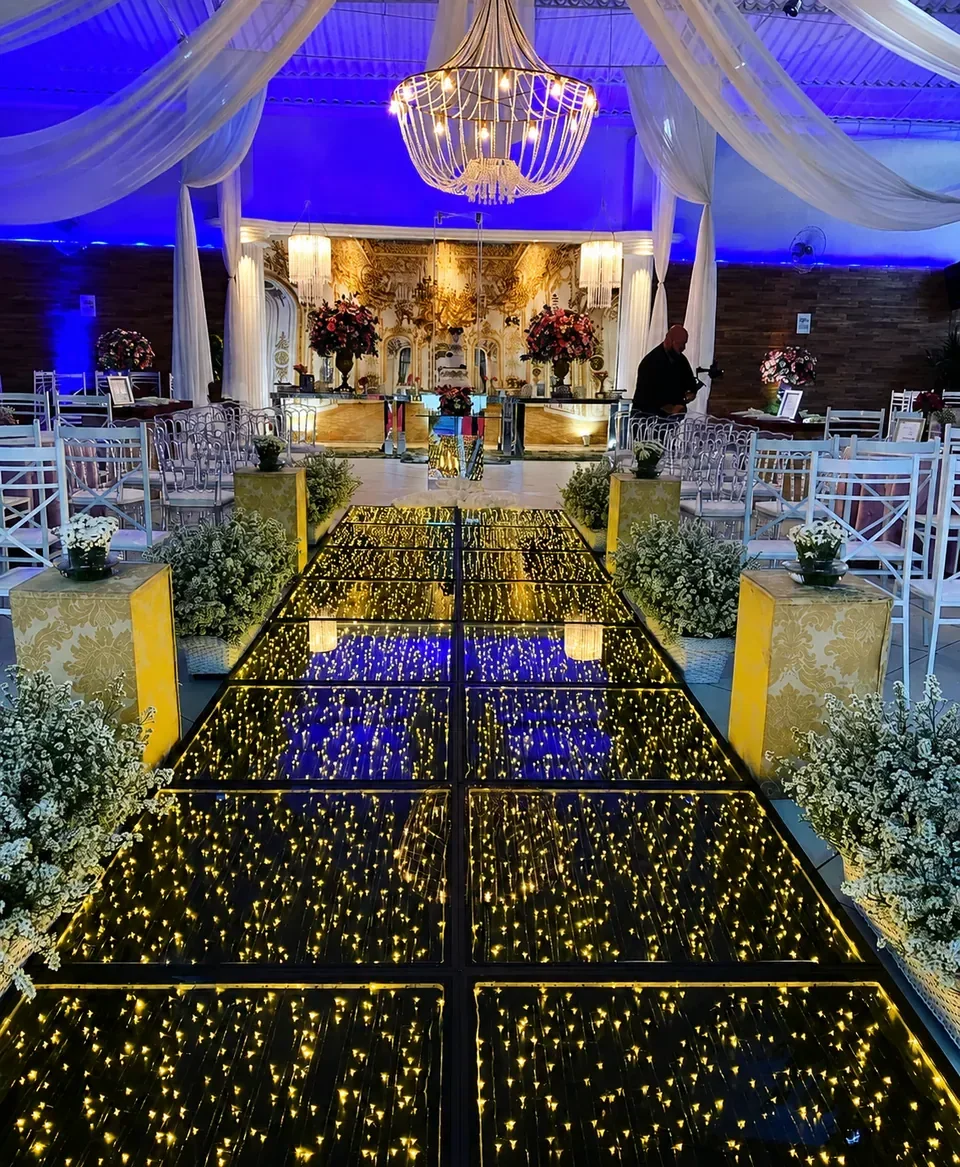 Pista infinita em cerimônia elegante. Passarela de LED conduzindo ao altar em uma composição com flores, lustre e iluminação cênica azul.