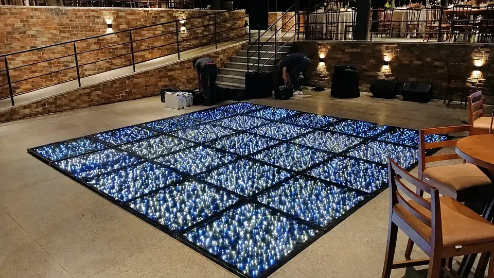 Pista de LED quadrada em espaço moderno. Montagem modular com pontos brancos e azuis pronta para integrar a pista de dança do evento.