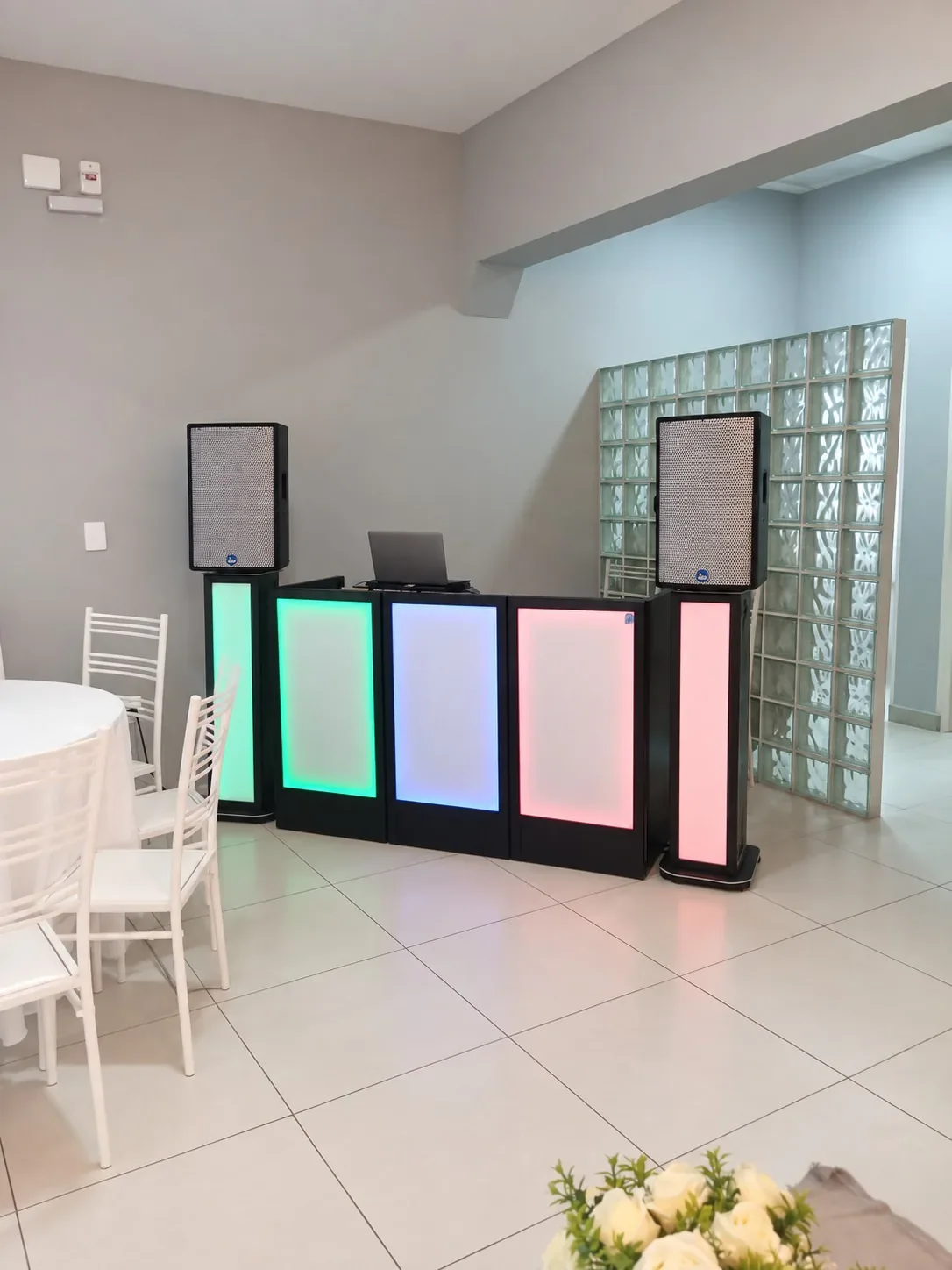 Montagem do Pacote Bronze com cabine de LED e duas caixas de som em um salão claro